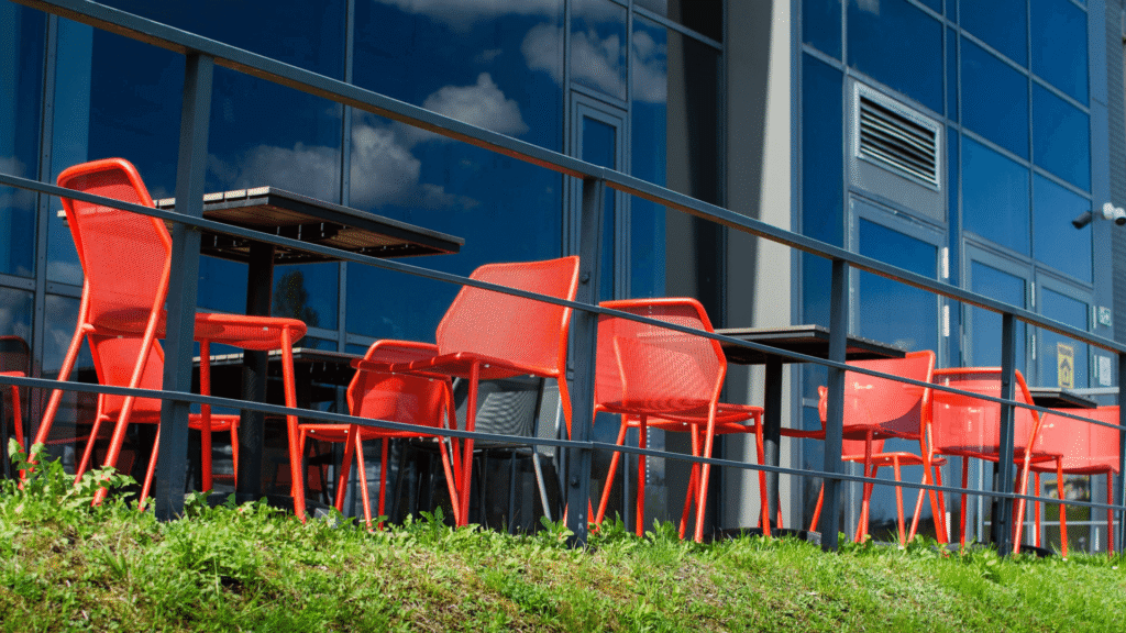 red patio chairs and black tables outside